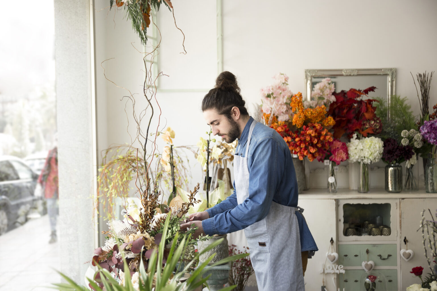 side-view-male-florist-arranging-flowers-his-flower-shop